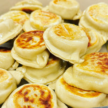 Load image into Gallery viewer, A close-up of golden-brown pan-fried pierogi.
