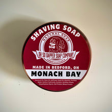 Load image into Gallery viewer, A round tin of Oh So Dapper Soap Company Monach Bay Shaving Soap, featuring a deep red label with white text and graphics, set against a plain off-white background.
